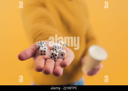 Fünf Würfel liegen auf einer Hand eines Kaukasierers. Studio auf gelbem Hintergrund. Hochwertige Fotos Stockfoto