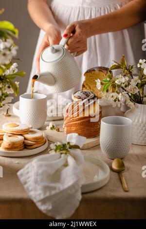 Frohe Ostern. Traditionelle Osterkuchen, hausgemachtes Kraffin mit Rosinen, kandierte Früchte. Kirschblüte auf weißem Beton Hintergrund. Selektiver Fokus. Schließen U Stockfoto