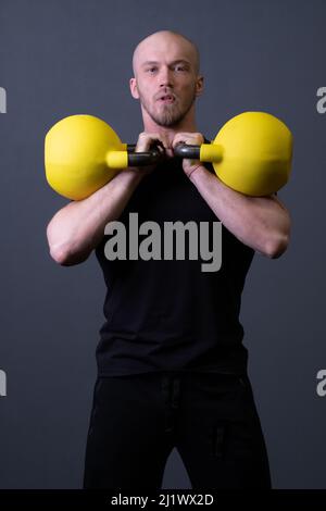 Kerl mit einem gelben Kettlebell-Fitnessstudio anonymen gelben Mann, für Motivation Lifestyle für Männer für bis Jugend, malaysische Fitness. Gesunde Intervallausdauer Stockfoto