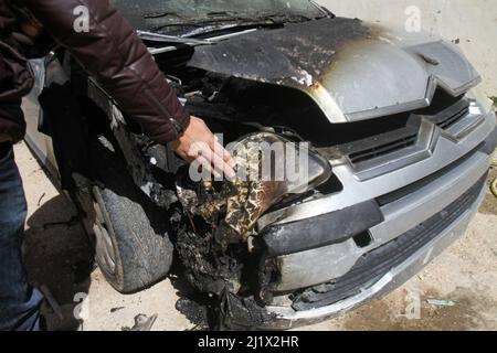 Nablus, Palästina. 28. März 2022. Ein Palästinenser inspiziert sein verbranntes Auto, nachdem israelische Siedler vier palästinensische Autos angezündet, ihr Eigentum zerstört und ihre Häuser im Dorf Jalud südlich von Nablus im besetzten Westjordanland zerstört haben. Viele der israelischen Siedler randalierten in den palästinensischen Dörfern in der Nähe der Außenposten nach einem Schussangriff von Palästinensern im besetzten Hadera-Gebiet im Jahr 1948. Kredit: SOPA Images Limited/Alamy Live Nachrichten Stockfoto