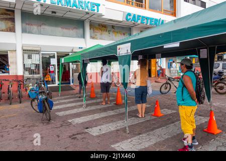 Schlange am Supermarkt, der normalerweise von Touristen und Einheimischen überfüllt ist, während der Covid-19-Sperre. Puerto Ayora, Santa Cruz Island, Galapagos Islands Ap Stockfoto