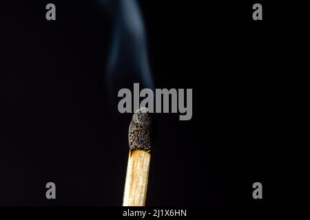 Ein verbranntes Match auf schwarzem Hintergrund Stockfoto