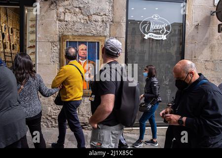 Barcelona, Spanien. 28. März 2022. Die Menschen blicken hinter den Gittern an einem Porträt von Wladimir Putin vorbei. Vladimir Putin Behind Bars ist in der neuen öffentlichen grafischen Collage auf der Plaza de Sant Jaume des in Barcelona lebenden italienischen Künstlers TvBoy vertreten. Kredit: SOPA Images Limited/Alamy Live Nachrichten Stockfoto