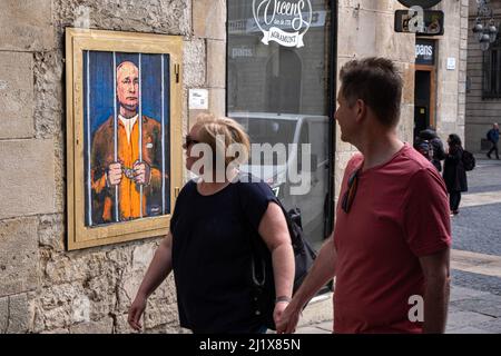 Barcelona, Spanien. 28. März 2022. Die Menschen blicken hinter den Gittern an einem Porträt von Wladimir Putin vorbei. Vladimir Putin Behind Bars ist in der neuen öffentlichen grafischen Collage auf der Plaza de Sant Jaume des in Barcelona lebenden italienischen Künstlers TvBoy vertreten. Kredit: SOPA Images Limited/Alamy Live Nachrichten Stockfoto