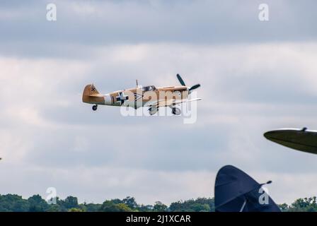 DUXFORD, CAMBRIDGESHIRE, Großbritannien - 13. JULI 2014: WW2 Bf (Messerschmitt) 109 führt während der Flying Legends eine Hundeschlacht-Ausstellung auf dem Flugplatz Duxford durch Stockfoto