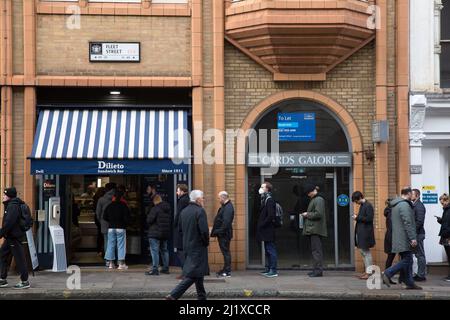 Vor einer Sandwich-Bar in London stehen die Leute zur Mittagszeit Schlange, da in England in der Vorwoche die Anweisungen von der Arbeit von zu Hause entfernt wurden. Stockfoto