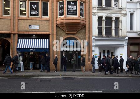 Vor einer Sandwich-Bar in London stehen die Leute zur Mittagszeit Schlange, da in England in der Vorwoche die Anweisungen von der Arbeit von zu Hause entfernt wurden. Stockfoto