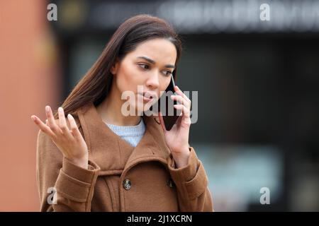 Wütende Frau auf der Straße, die sich über das Mobiltelefon beschwerte Stockfoto