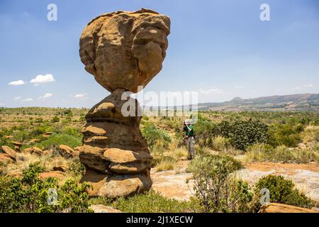 Ein Foto, das ein Foto eines hohen, balancierenden Felsens wie eine Felssäule an einem sonnigen Tag in den Magaliesberg Mountains, Südafrika, macht Stockfoto