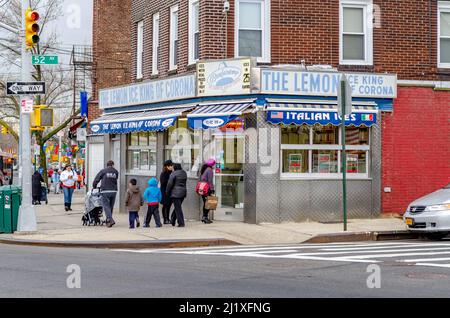 Der Lemon Ice King von Corona mit Menschen, Fußgängerüberweg und Stadtstraße vor dem Hotel, Eisdiele, Queens, New York City während des bewölkten Wintertages Stockfoto