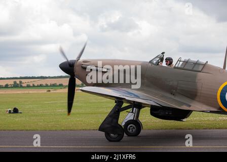 DUXFORD, CAMBRIDGESHIRE, Großbritannien - 13. JULI 2014: WW2 der Hawker-Sturmflug (RAF) führt eine Hundeschlacht-Ausstellung durch und fliegt schnell am Flugplatz von Duxford vorbei. Stockfoto