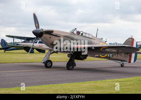 DUXFORD, CAMBRIDGESHIRE, Großbritannien - 13. JULI 2014: WW2 der Hawker-Sturmflug (RAF) führt eine Hundeschlacht-Ausstellung durch und fliegt schnell am Flugplatz von Duxford vorbei. Stockfoto