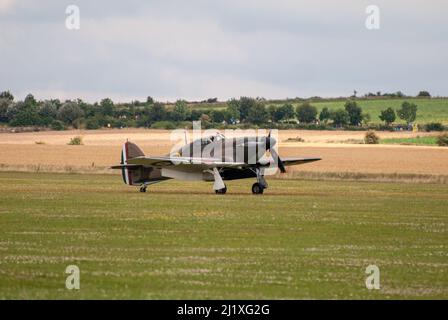 DUXFORD, CAMBRIDGESHIRE, Großbritannien - 13. JULI 2014: WW2 der Hawker-Sturmflug (RAF) führt eine Hundeschlacht-Ausstellung durch und fliegt schnell am Flugplatz von Duxford vorbei. Stockfoto