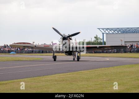 DUXFORD, CAMBRIDGESHIRE, Großbritannien - 13. JULI 2014: WW2 der Hawker-Sturmflug (RAF) führt eine Hundeschlacht-Ausstellung durch und fliegt schnell am Flugplatz von Duxford vorbei. Stockfoto