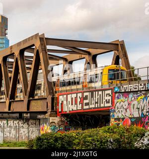 Eisenbahnbrücke mit Graffiti vom Station Park in der Spitalfields-Gegend von London aus gesehen. Stockfoto