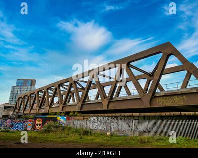 Eisenbahnbrücke mit Graffiti vom Station Park in der Spitalfields-Gegend von London aus gesehen. Stockfoto