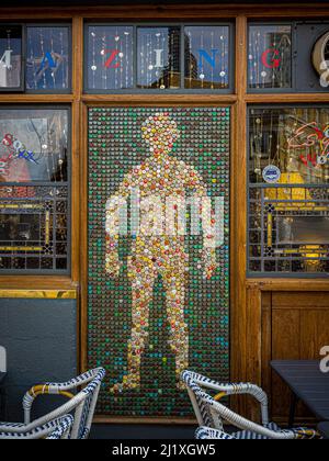 Kunstwerke aus Bierflaschenoberteilen an der Außenseite façade des Golden Heart, einem denkmalgeschützten Pub der Klasse II in Spitalfields, London. Stockfoto