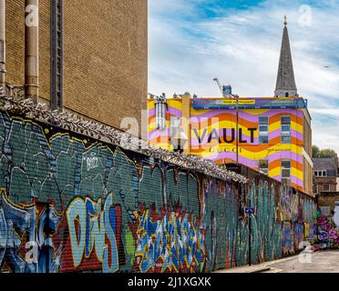 Das Äußere des Vault Gucci von der Grey Eagle Street aus gesehen, mit dem Spitalfields-Turm der Christ Church in der Ferne. London Stockfoto