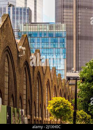 Viktorianische Backsteinfassade façade der Liverpool Street Station von der Sun Street Passage aus gesehen, mit modernen Hochhäusern in der Ferne. London. Stockfoto