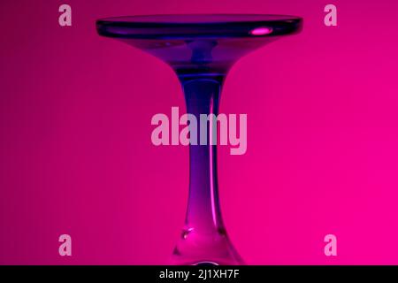 Glas, das von unten mit farbigem Licht beleuchtet wird, erzeugt raubende Muster, die als Hintergrund verwendet werden können Stockfoto