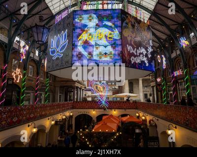 Beleuchtetes achteckiges Herzstück, Teil einer Neonlicht-Kunstinstallation von Chila Burman in der Market Hall in Covent Garden, London. Stockfoto