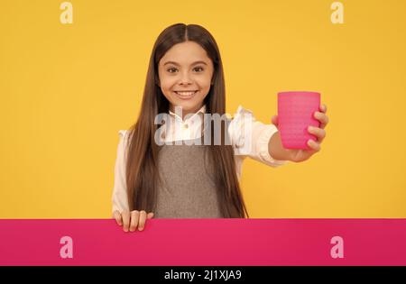 Glücklich Tween Mädchen geben Plastikbecher mit Getränk hält Werbung Brett für Kopie Raum, Getränk Stockfoto