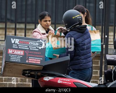 London, Großbritannien. 27. März 2022. AKSHATA MURTY (links), die Frau von Kanzler RISHI SUNAK, wird gesehen, wie sie eine Deliveroo-Lieferung zur Mittagszeit am hinteren Eingang zur Downing Street in Westminster erhält. Letzte Woche hat die Bundeskanzlerin die Frühjahrserklärung IS abgegeben, die eine Reihe von Maßnahmen zur Linderung der wachsenden Lebenshaltungskosten umfasst. Bildnachweis: Ben Cawthra/Sipa USA **KEINE Verkäufe in Großbritannien** Bildnachweis: SIPA USA/Alamy Live News Stockfoto