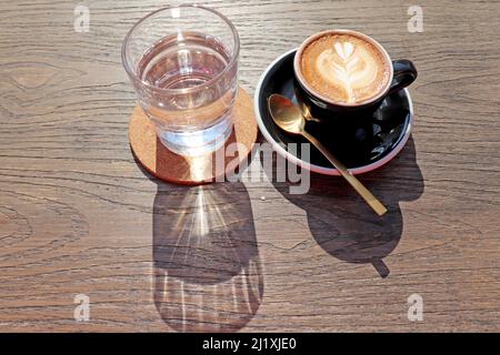 Latte Art, Kaffeekunst von Barista auf Holzhintergrundtisch, Blick von oben oder von oben. Platz für Text auf der linken Seite kopieren. Stockfoto