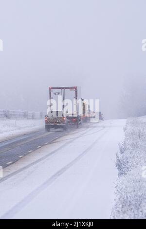 Der Verkehr auf der A417 außerhalb von Cirencester kämpft mit nächtlichem Schnee, Spray und Eis, was gefährliche Fahrbedingungen zur Verfügung stellt. Stockfoto