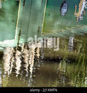 Die abstrakte Fotografie der britischen Wasserstraße zeigt reflektierte Muster, Textur, Form und Bewegung, mit einer Farbpalette in hellen Spiegelformen Stockfoto