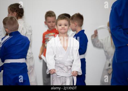 Weißrussland, Stadt Gomel, 15. Dezember 2021. Judo Schule für Kinder. Kleiner Junge in Kimano im Training. Stockfoto