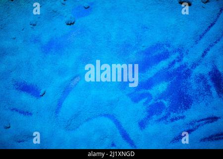 Hintergrund aus blau verstreutem Sand.Bunter Sand und buntes Pulver. Stockfoto