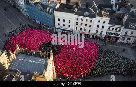 Cirencester, Großbritannien. Am Marktplatz der Stadt Cirencester versammeln sich Menschen, um einen Weltrekord zu bilden (anstehende Exformation), um an das Ende des Ersten Weltkriegs vor 100 Jahren zu erinnern. Über 3.300 Menschen trugen farbige Ponchos, um die Form eines Mohns und eines Blattes zu kreieren. Stockfoto