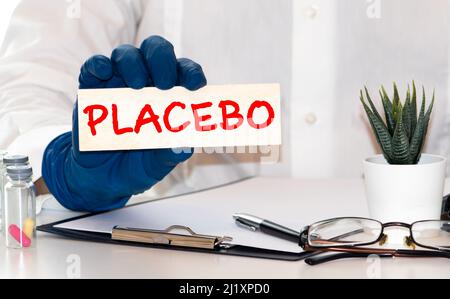 Wörter mit Placebo-Effekt, die auf einem blauen medizinischen Ordner mit Patientenakten, Pillen und Stethoskop auf dem Hintergrund geschrieben sind Stockfoto