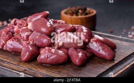 Rohe Hühnerherzen auf Holzhintergrund, Nahaufnahme. Konzept der gesunden Ernährung Stockfoto