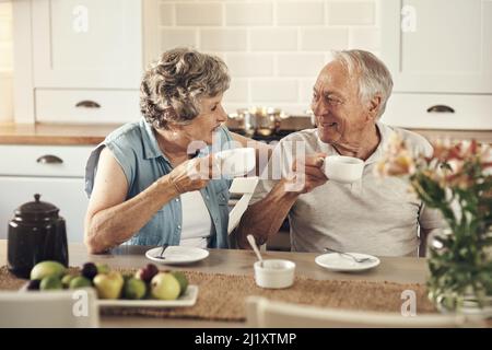 Eine gute Tasse Kaffee gibt den Ton für den Tag. Aufnahme eines älteren Paares, das zu Hause zusammen gefrühstückt hat. Stockfoto