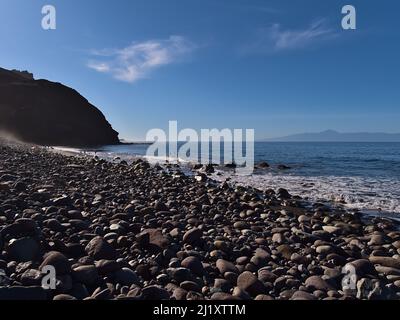 Menschen schwimmen im Meer am schönen Strand Playa del Risco an der Westküste von Gran Canaria, Kanarische Inseln, Spanien mit Felsen. Stockfoto