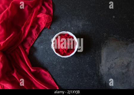 Gulal oder holi Festival rote Farbe auf einem dunklen Hintergrund. Stockfoto