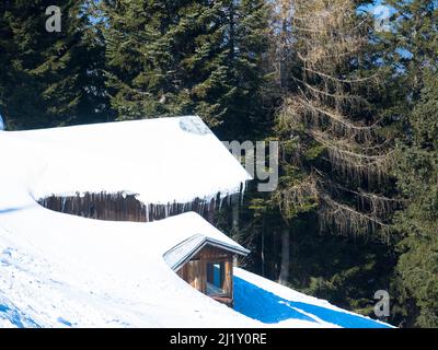 Winterhaus mit Schneeschichten bedeckt. Alte, beeindruckende, schneebedeckte Skihütte in den österreichischen alpen Stockfoto