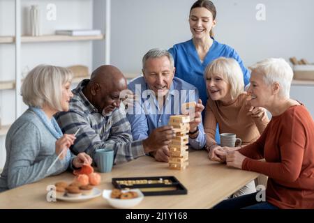 Glückliche multirassische Gruppe von Rentnern, die Tischspiele spielen Stockfoto