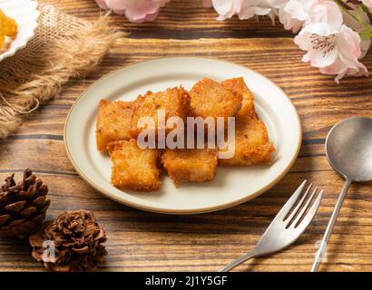 Gerührter gebratener Rübenkuchen in der Teller-Seitenansicht auf Holztisch taiwanesisches Essen Stockfoto