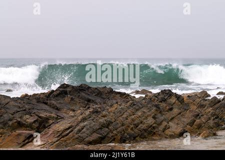 Meeresbrause, brechende Wellen an Felsküsten, anschwellen Energie an der Küste. Meeresenergie bei hohen Gezeiten. Meer- oder Playa-Themen mit Felsen und Wellen. Inseln. Stockfoto