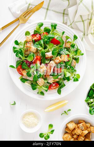 Caesar-Salat mit gegrilltem Hähnchenfleisch, frischen Tomaten, Croutons, Lämmersalat und Parmesankäse, Blick von oben Stockfoto
