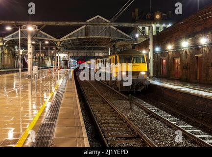 Die 2350 London Euston - Glasgow und Edinburgh Caledonian Sleeper wartet an Preston in den frühen Morgenstunden von einer Freightliner Class 90 elektrische Lok Stockfoto