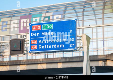 Verkehrsschild mit Entfernungen zu den drei größten Städten der Niederlande: Amsterdam, Rotterdam und Den Haag. Stockfoto