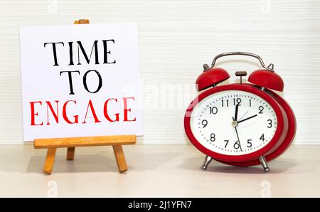 Wecker und Notiz mit REDEZEIT AUF weißem Hintergrund, Platz für Text. Stockfoto