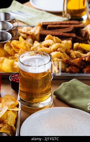 Tischset mit Bier und salzigen Snacks Stockfoto