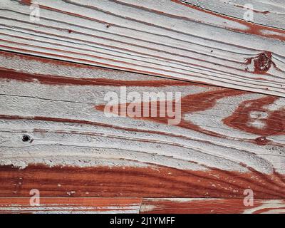 Nahaufnahme von rötlich-brauner verblassener Farbe auf verwittertem Holz Stockfoto