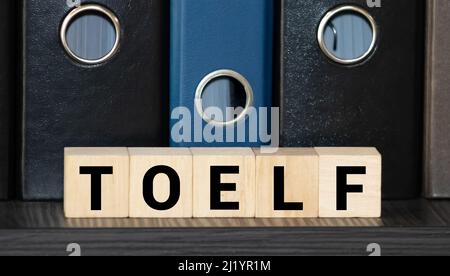 TOEFL - Wörter aus Holzblöcken mit Buchstaben, der Test des Englischen als Fremdsprache, TOEFL-Konzept, weißer Hintergrund Stockfoto