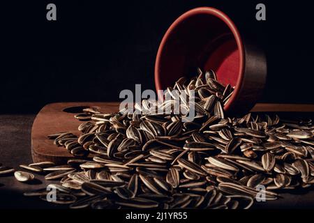 Sonnenblumenkerne in einer umgekehrten Schüssel Nahaufnahme auf dem alten Küchentisch, selektiver Fokus. Stockfoto